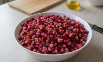 Классический винегрет в белой миске на кухонном столе
